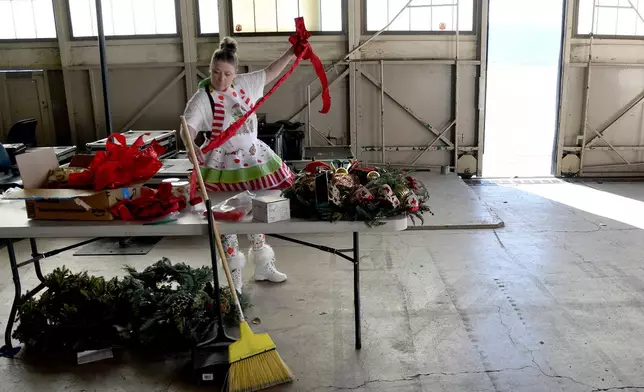 Designer Michelle Reid prepares holiday decorations inside a hangar at Peterson Space Force Base in Colorado Springs, Colo., on Thursday, Dec. 18, 2025 in advance of the annual NORAD Tracks Santa Operation, at the North American Aerospace Defense Command. (AP Photo/Thomas Peipert)
