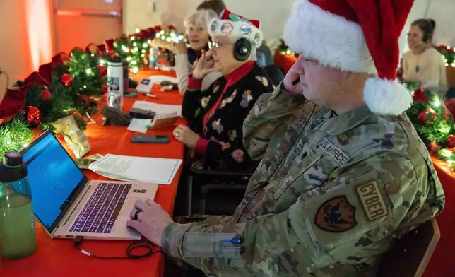 Volunteers take phone calls from children asking where Santa is and when he will deliver presents to their house, during the annual NORAD Tracks Santa Operation, at the North American Aerospace Defense Command, or NORAD, at Peterson Air Force Base, in Colorado Springs, Colo., on Tuesday, Dec. 24, 2024. (Thomas Paul/North American Aerospace Defense Command. via AP)