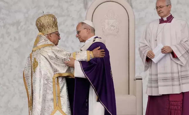 Pope Leo XIV is greeted by Patriarch of Antioch of the Greek-Melkites Youssef Absi as he celebrates a Holy Mass at Beirut waterfront, in Beirut, Lebanon, Tuesday, Dec. 2, 2025. (AP Photo/Bilal Hussein)