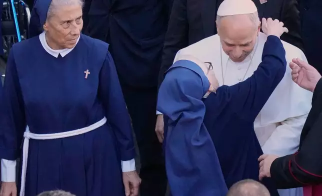 The superior general of the Psychiatric Hospital of the Cross, Mother Marie Makhlouf, left, looks on as Pope Leo XIV is greeted by a nun as he arrives hospital, in the town of Jal el-Dib, north of Beirut, Lebanon, Tuesday, Dec. 2, 2025. (AP Photo/Hassan Ammar)