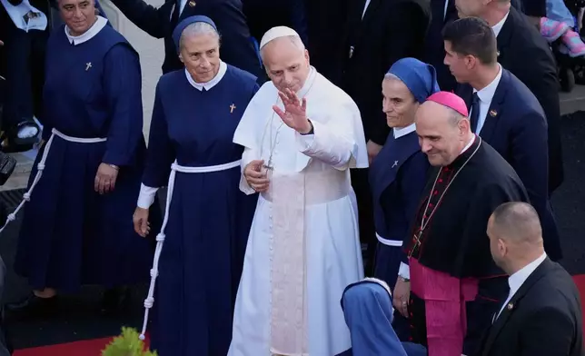 The superior general of the Psychiatric Hospital of the Cross, Mother Marie Makhlouf, center left, walks beside Pope Leo XIV as he waves upon his arrival at the hospital in the town of Jal el-Dib, north of Beirut, Lebanon, Tuesday, Dec. 2, 2025. (AP Photo/Hassan Ammar)