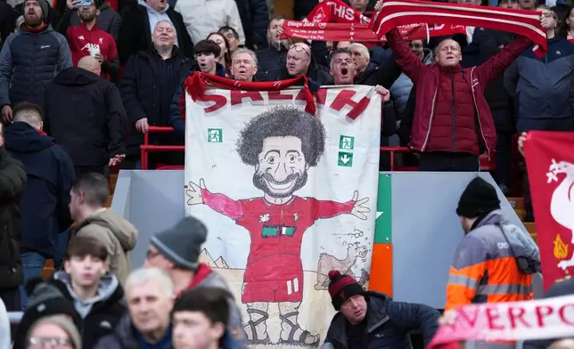 Liverpool fans hold placard depicting Liverpool's Mohamed Salah before the English Premier League soccer match between Liverpool and Brighton and Hove Albion in Liverpool, England, Saturday, Dec. 13, 2025. (AP Photo/Jon Super)