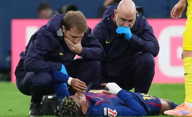 Barcelona's Lamine Yamal lies on the pitch in pain during the Spanish La Liga soccer match between Villarreal and Barcelona in Villarreal, Spain, Sunday, Dec. 21, 2025. (AP Photo/Alberto Saiz)