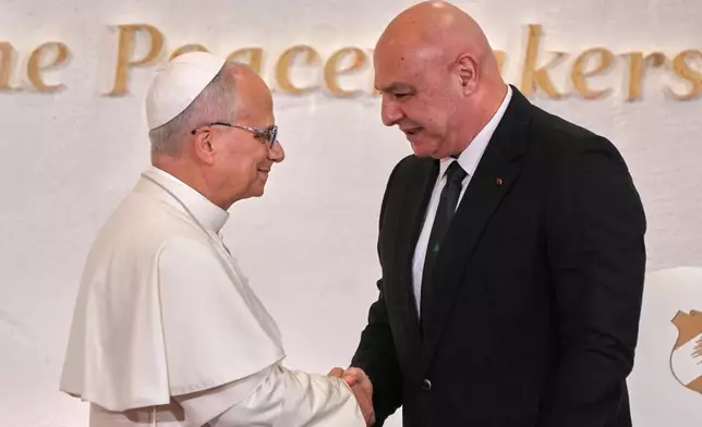 Lebanese President Joseph Aoun, right, shakes hands with Pope Leo XIV as they meet at Beirut's Presidential palace, Lebanon, Sunday, Nov. 30, 2025. (AP Photo/Domenico Stinellis)