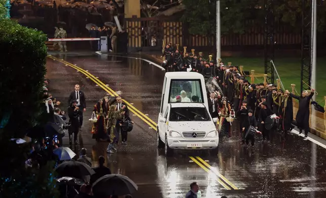 In this photo released by the Lebanese Presidency press office, Lebanese dancers, wearing folk costume, perform the traditional Lebanese "dabkeh" dance, as they welcome Pope Leo XIV in his pope mobile upon his arrival at the presidential palace in Baabda, east of Beirut, Lebanon, Sunday, Nov. 30, 2025. (Lebanese Presidency press office via AP)