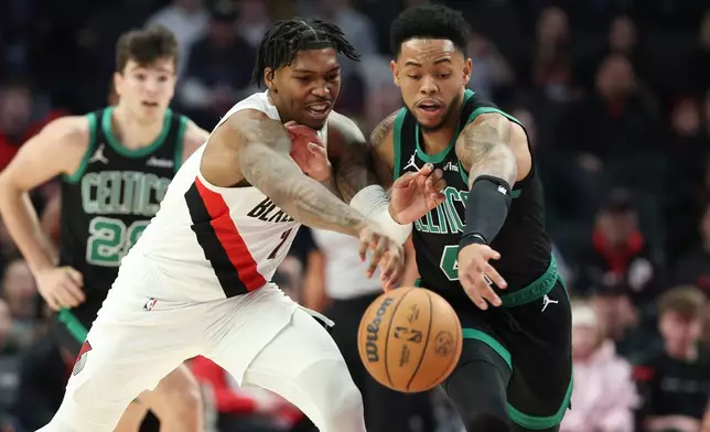 Portland Trail Blazers guard Caleb Love (2) and Boston Celtics guard Anfernee, right, Simons battle for a loose ball during the first half of an NBA basketball game, Sunday, Dec. 28, 2025, in Portland, Ore. (AP Photo/Amanda Loman)