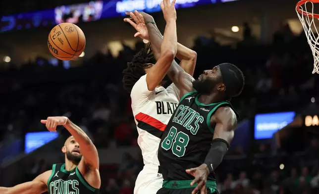 Portland Trail Blazers guard Shaedon Sharpe, center, and Boston Celtics center Neemias Queta, right, collide during the second half of an NBA basketball game Sunday, Dec. 28, 2025, in Portland, Ore. (AP Photo/Amanda Loman)