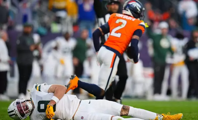 Green Bay Packers' Christian Watson is hurt after Denver Broncos' Pat Surtain II intercepts a pass during the second half of an NFL football game Sunday, Dec. 14, 2025, in Denver. (AP Photo/Jack Dempsey)
