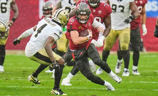 Tampa Bay Buccaneers quarterback Baker Mayfield (6) carries against New Orleans Saints cornerback Kool-Aid McKinstry (4) in the first half of an NFL football game, Sunday, Dec. 7, 2025, in Tampa, Fla. (AP Photo/Chris O'Meara)