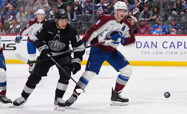 Los Angeles Kings left wing Trevor Moore, left, and Colorado Avalanche defenseman Cale Makar pursue the puck in the second period of an NHL hockey game Monday, Dec. 29, 2025, in Denver. (AP Photo/David Zalubowski)