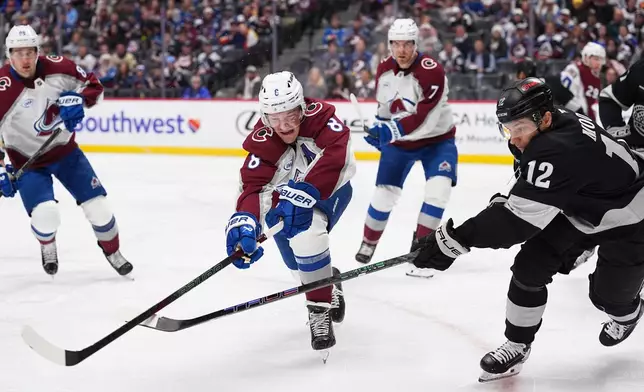 Colorado Avalanche defenseman Cale Makar, left, and Los Angeles Kings left wing Trevor Moore pursue the puck in the second period of an NHL hockey game Monday, Dec. 29, 2025, in Denver. (AP Photo/David Zalubowski)
