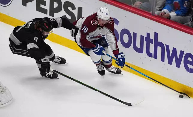 Colorado Avalanche center Jack Drury, right, collects the puck as Los Angeles Kings right wing Adrian Kempe, left, defends in the first period of an NHL hockey game Monday, Dec. 29, 2025, in Denver. (AP Photo/David Zalubowski)