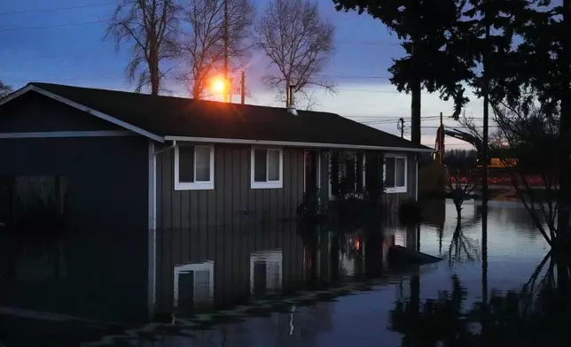 Floodwaters surround a home after heavy rains led to historic flooding in the region Saturday, Dec. 13, 2025, in Burlington, Wash. (AP Photo/Lindsey Wasson)