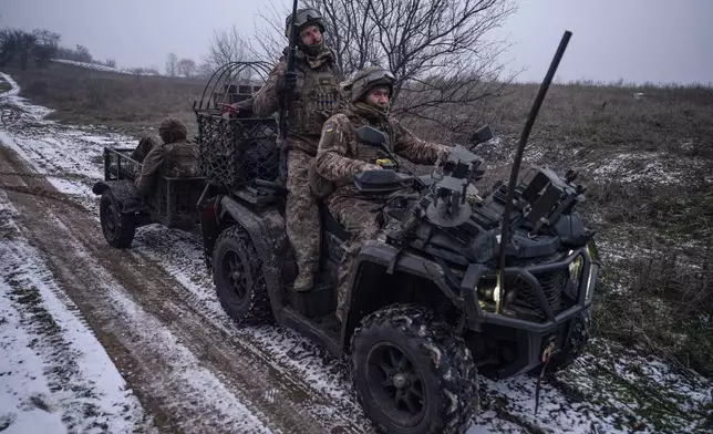 In this photo, taken Tuesday, Dec. 16, 2025 and provided by Ukraine's 93rd Kholodnyi Yar Separate Mechanized Brigade press service, soldiers ride a quad bike near Kostyantynivka, Donetsk region, Ukraine. (Iryna Rybakova/Ukraine's 93rd Mechanized Brigade via AP)