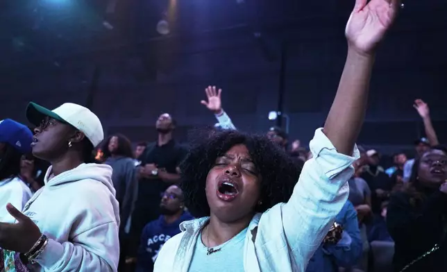 A churchgoer lifts her arm in worship at 2819 Church on Nov. 16, 2025, in Atlanta. (AP Photo/Jessie Wardarski)