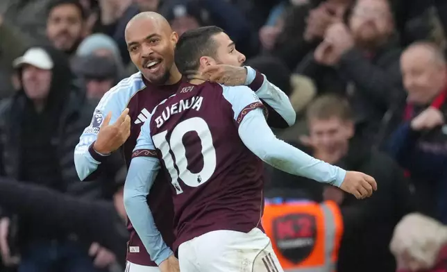 Aston Villa's Emiliano Buendia, right, celebrates with Aston Villa's Donyell Malen after scoring his side's second goal during the English Premier League soccer match between Aston Villa and Arsenal in Birmingham, England, Saturday, Dec. 6, 2025. (AP Photo/Dave Shopland)