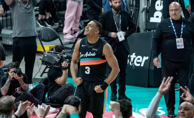San Antonio Spurs forward Keldon Johnson (3) celebrates a three point basket against the Oklahoma Thunder during the second half of an NBA basketball game in San Antonio, Tuesday, Dec. 23, 2025. (AP Photo/Rodolfo Gonzalez)
