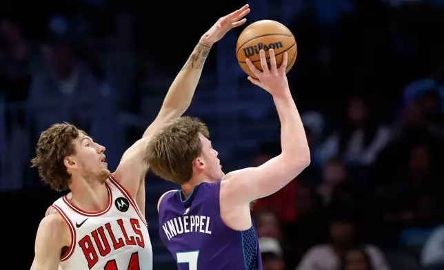 Charlotte Hornets guard Kon Knueppel, right, looks to shoot against Chicago Bulls forward Matas Buzelis, left, during the first half of an NBA basketball game in Charlotte, N.C., Friday, Dec. 12, 2025. (AP Photo/Nell Redmond)