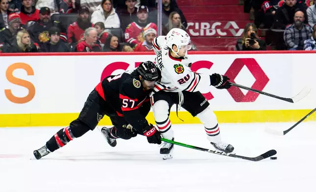 Ottawa Senators' David Perron (57) fights for control of the puck against Chicago Blackhawks' Ryan Greene (20) during second-period NHL hockey game action in Ottawa, Ontario, Saturday, Dec. 20, 2025. (Spencer Colby/The Canadian Press via AP)