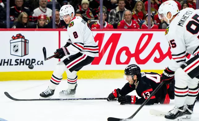 Chicago Blackhawks center Ryan Donato (8) shoots on net as Ottawa Senators defenseman Tyler Kleven (43) loses his balance during first-period NHL hockey game action in Ottawa, Ontario, Saturday, Dec. 20, 2025. (Spencer Colby/The Canadian Press via AP)