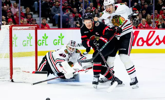 Ottawa Senators' Brady Tkachuk (7) chases down the puck while under pressure from Chicago Blackhawks' Louis Crevier (46) during second-period NHL hockey game action in Ottawa, Ontario, Saturday, Dec. 20, 2025. (Spencer Colby/The Canadian Press via AP)