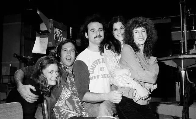 FILE - Comedian Chevy Chase, second from left, joins cast of NBC-TV's "Saturday Night Live," Feb. 16, 1978 in New York, where he first got his start with the "Not Ready For Prime Time Players." Others are, from left, Jane Curtin, Bill Murray, Gilda Radner, and Laraine Newman. Chase is doing a guest shot on the program. (AP Photo/Marty Lederhandler, File)