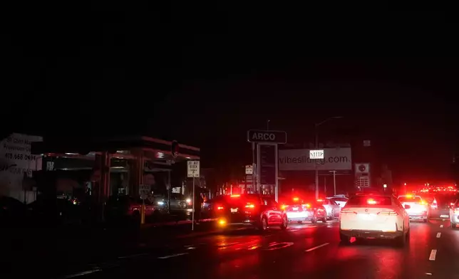 Cars wait at an intersection with no working traffic lights from power outages, in San Francisco, Saturday, Dec. 20, 2025. (AP Photo/Jeff Chiu)
