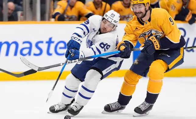 Toronto Maple Leafs left wing Nicholas Robertson (89) and Nashville Predators left wing Filip Forsberg (9) chase a loose puck during the third period of an NHL hockey game Saturday, Dec. 20, 2025, in Nashville, Tenn. (AP Photo/George Walker IV)