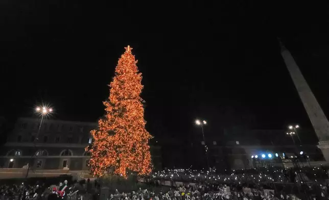 Rome's Mayor Roberto Gualtieri, left, lights up a giant Christmas tree in central Piazza del Popolo in Rome, Monday, Dec. 8, 2025. (AP Photo/Andrew Medichini)
