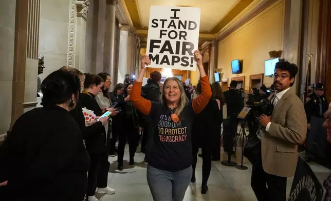 A protester celebrates as they walk outside the Indiana Senate Chamber after a bill to redistrict the state's congressional map was defeated, Thursday, Dec. 11, 2025, at the Statehouse in Indianapolis. (AP Photo/Michael Conroy)