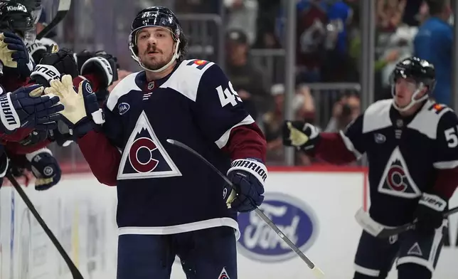 Colorado Avalanche defenseman Samuel Girard is congratulated as he passes the team box after scoring a goal against the Utah Mammoth in the second period of an NHL hockey game, Tuesday, Dec. 23, 2025, in Denver. (AP Photo/David Zalubowski)