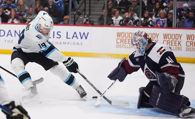 Colorado Avalanche goaltender Scott Wedgewood, right, stops a shot by Utah Mammoth left wing Daniil But in the second period of an NHL hockey game Tuesday, Dec. 23, 2025, in Denver. (AP Photo/David Zalubowski)