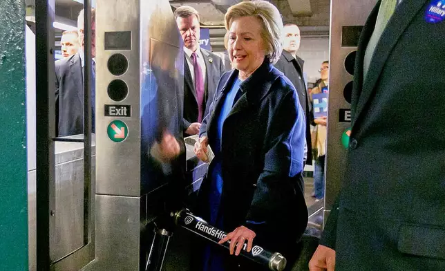 FILE - Democrat presidential candidate Hillary Clinton holds her MetroCard as she goes through the turnstile to enter the subway in the Bronx borough of New York, April 7, 2016. (AP Photo/Richard Drew, File)