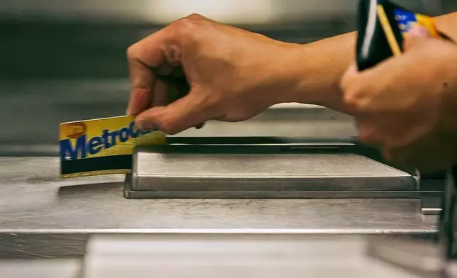 FILE - A subway rider swipes his MetroCard in a turnstile as he enters the 34th St. subway station, July 23, 2007, in New York. (AP Photo/Mary Altaffer, File)