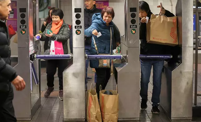 FILE - Shoppers swipe their MetroCards as they enter the subway turnstiles, Nov. 29, 2024, in New York. (AP Photo/Heather Khalifa, File)