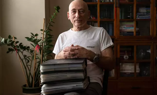 Lev Radin poses for a picture with his MetroCard collection, Dec. 10, 2025, in New York. (AP Photo/Yuki Iwamura)
