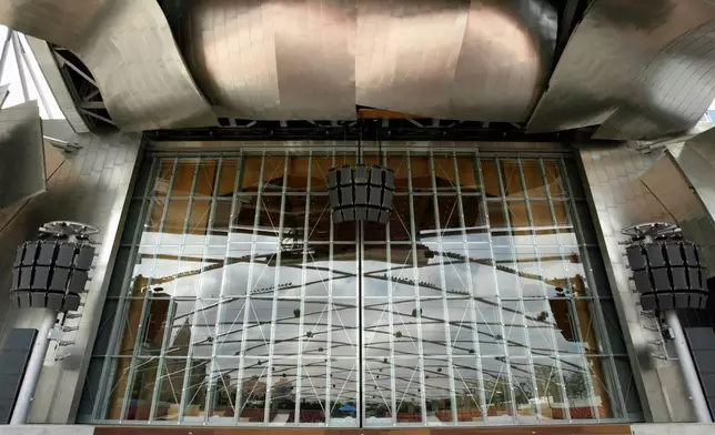 FILE - A trellis of curved steel pipes are reflected in glass doors on the stage area at the new band shell in Chicago's Millennium Park, July 7, 2004. The $52 million band shell, with its stage surrounded by billowing ribbons of stainless steel, was designed by famed architect Frank Gehry. (AP Photo/Nam Y. Huh, File)