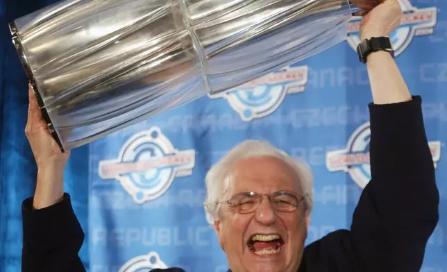 FILE - World renowned architect Frank Gehry hoists the World Cup of Hockey Championship trophy, which he designed, at a news conference in Toronto, May 12, 2004. (AP Photo/Adrian Wyld, File)