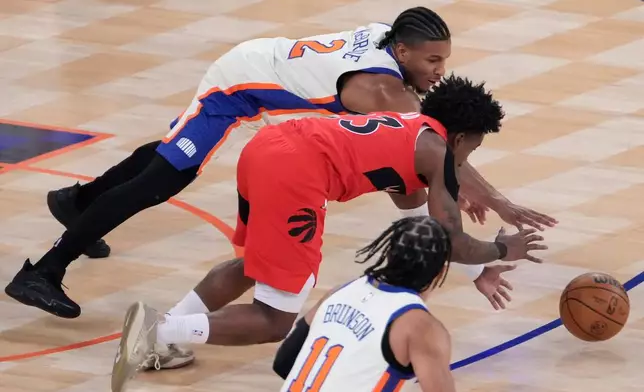 Toronto Raptors guard Jamal Shead (23) and New York Knicks guard Miles McBride (2) reach for the ball during the first half of an NBA basketball game Sunday, Nov. 30, 2025, in New York. (AP Photo/Yuki Iwamura)