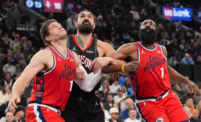 Houston Rockets center Steven Adams, center, fights for position with Los Angeles Clippers center Brook Lopez, left, and guard James Harden during the first half of an NBA basketball game Tuesday, Dec. 23, 2025, in Inglewood, Calif. (AP Photo/Jae C. Hong)