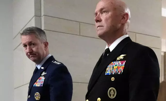 U.S. Navy Adm. Frank M. Bradley, right, accompanied by Gen. Dan Caine, chairman of the Joint Chiefs of Staff, left, walks to a meeting with senators on Capitol Hill, Thursday, Dec. 4, 2025, in Washington. (AP Photo/Mark Schiefelbein)