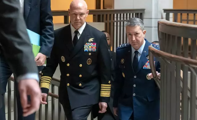 U.S. Navy Adm. Frank M. Bradley, accompanied by Gen. Dan Caine, chairman of the Joint Chiefs of Staff, right, walks to a meeting with senators on Capitol Hill, Thursday, Dec. 4, 2025, in Washington. (AP Photo/Mark Schiefelbein)
