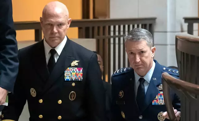 U.S. Navy Adm. Frank M. Bradley, accompanied by Gen. Dan Caine, chairman of the Joint Chiefs of Staff, right, walks to a meeting with senators on Capitol Hill, Thursday, Dec. 4, 2025, in Washington. (AP Photo/Mark Schiefelbein)