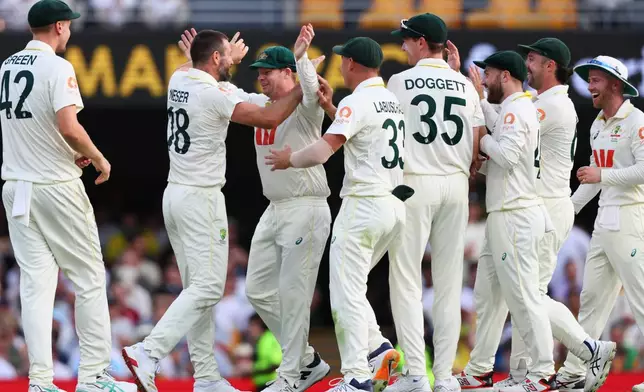 Australia's Michael Neser, second left, celebrates with teammates the wicket of England's Will Jacks during the second Ashes cricket test match between Australia and England in Brisbane, Sunday, Dec. 7, 2025.. (AP Photo/Tertius Pickard)