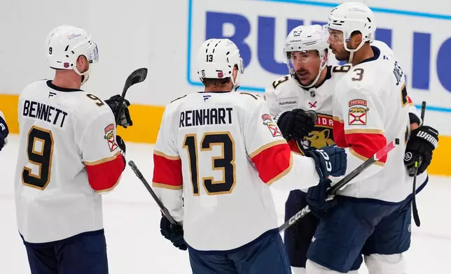 Florida Panthers' Sam Bennett (9), Sam Reinhart (13), Brad Marchand and Seth Jones (3) celebrate Marchand's goal against the Dallas Stars in the second period of an NHL hockey game in Dallas, Saturday, Dec. 13, 2025. (AP Photo/Tony Gutierrez)