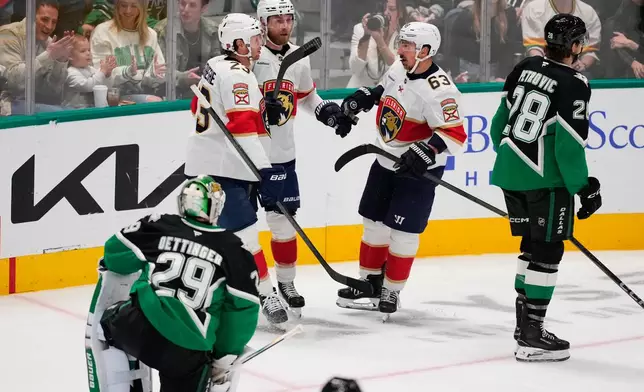Florida Panthers' Carter Verhaeghe (23), Sam Bennett (9) and Brad Marchand (63) celebrate Bennett's goal as Dallas Stars' Jake Oettinger (29) and Alexander Petrovic (28) look on in the second period of an NHL hockey game in Dallas, Saturday, Dec. 13, 2025. (AP Photo/Tony Gutierrez)