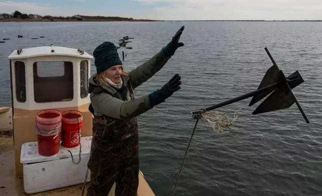 Retired WNBA star and Hall of Famer Sue Wicks throws an anchor from her boat in Moriches Bay in New York, Thursday, Nov. 20, 2025. (AP Photo/Yuki Iwamura)