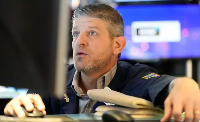 Michael Gallucci works on the floor at the New York Stock Exchange in New York, Wednesday, Dec. 10, 2025. (AP Photo/Seth Wenig)