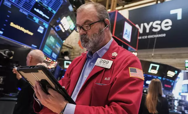Trader William Lawrence works on the floor of the New York Stock Exchange, Thursday, Dec. 11, 2025. (AP Photo/Richard Drew)