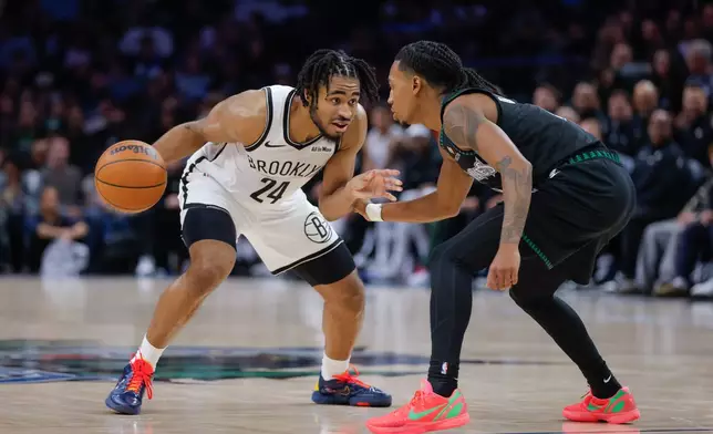 Brooklyn Nets guard Cam Thomas (24) handles the ball while Minnesota Timberwolves guard Rob Dillingham, right, defends during the second half of an NBA basketball game, Saturday, Dec. 27, 2025, in Minneapolis. (AP Photo/Bailey Hillesheim)